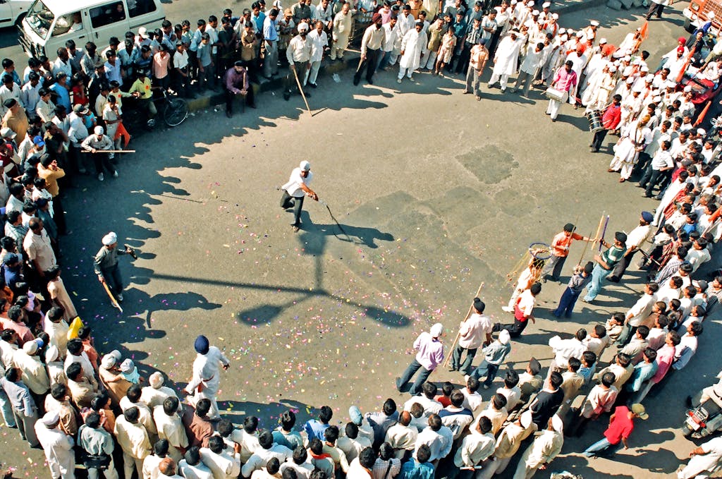 Aerial view of a festive gathering with a martial arts demonstration in Pune, India.